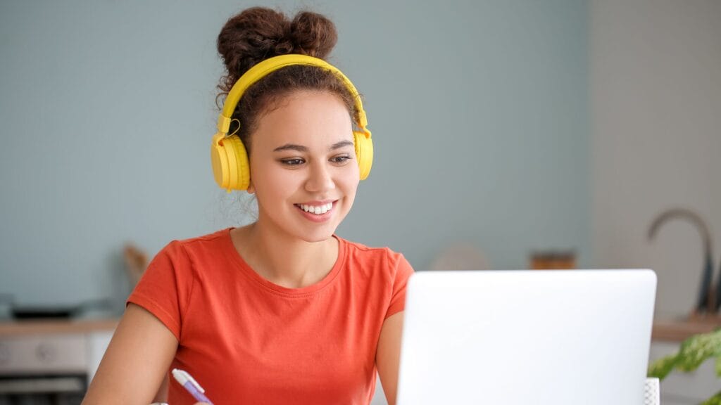 Girl with orange shirt in front of computer